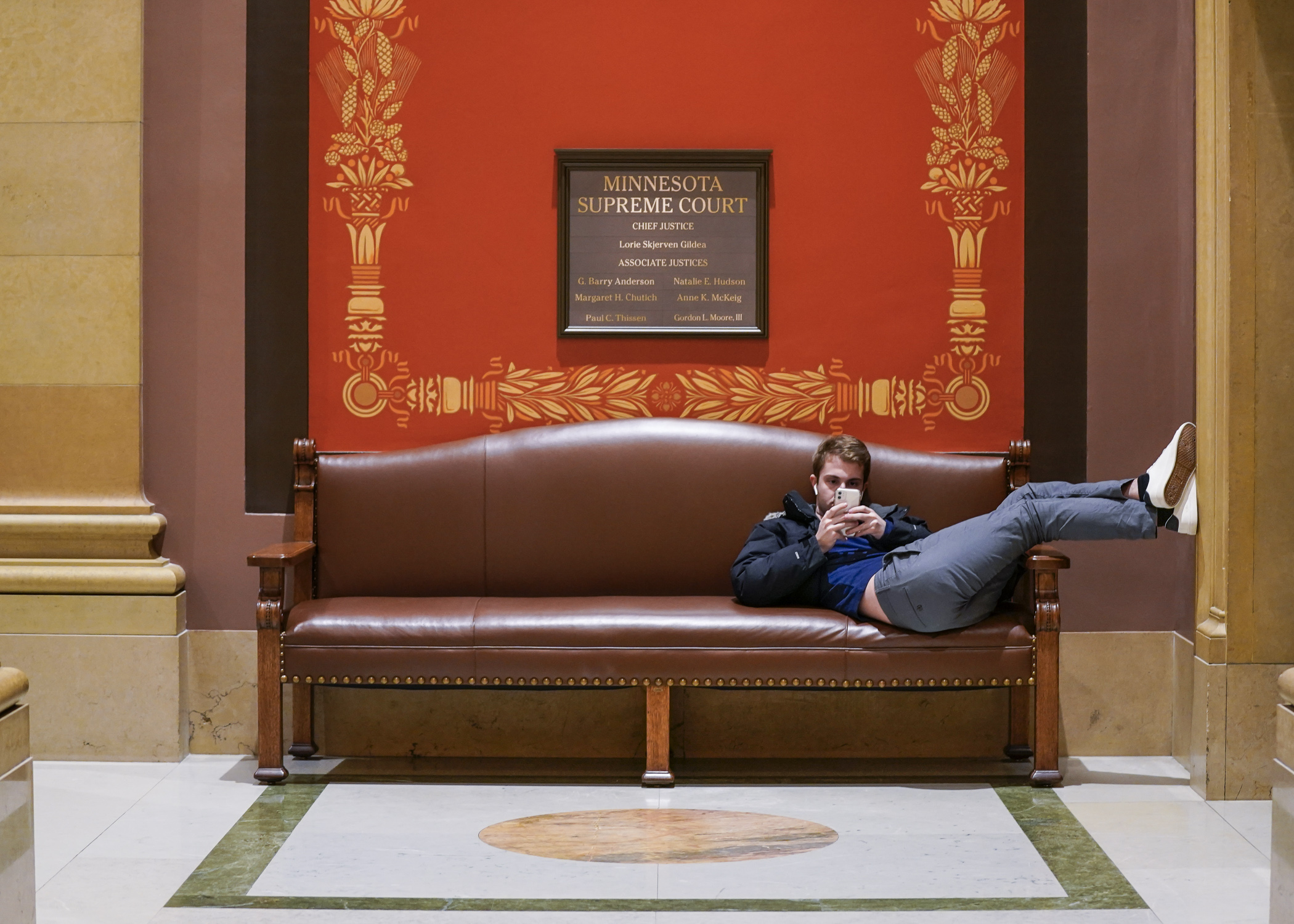 A State Capitol visitor lounges near the Minnesota Supreme Court chamber March 1. (Photo by Catherine Davis)